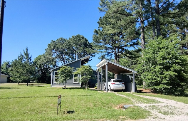 exterior space featuring driveway, a front yard, and a carport