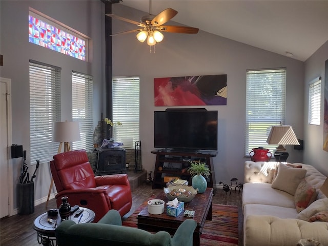 living room with a wood stove, wood finished floors, baseboards, high vaulted ceiling, and a ceiling fan