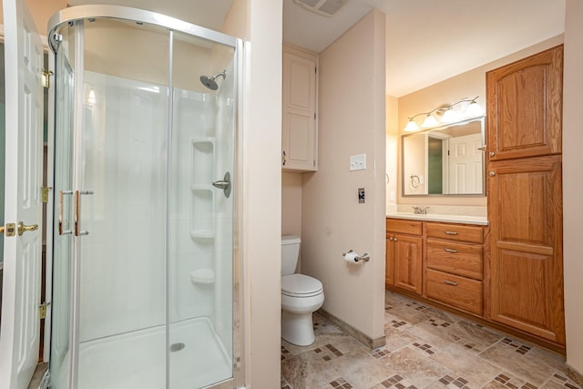 bathroom featuring vanity, baseboards, a stall shower, and toilet