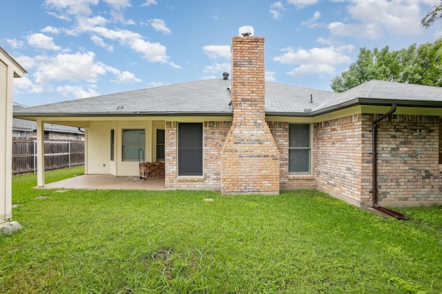 back of house featuring a patio, fence, a yard, and a chimney