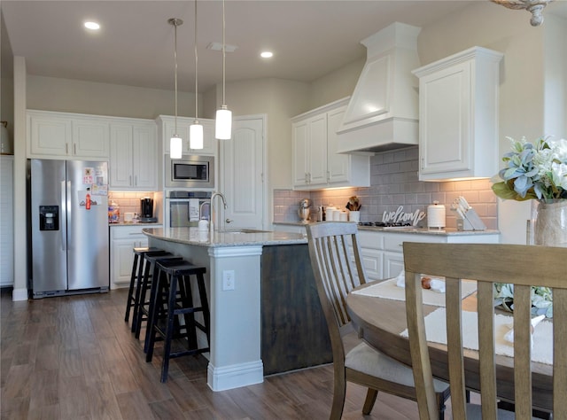 kitchen featuring a sink, stainless steel appliances, white cabinetry, tasteful backsplash, and custom exhaust hood