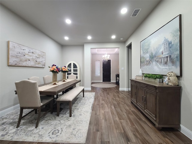 dining room featuring an inviting chandelier, visible vents, baseboards, recessed lighting, and dark wood finished floors
