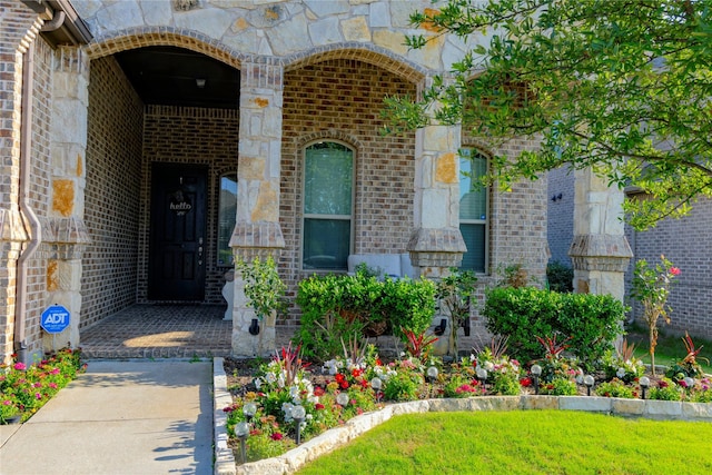 view of exterior entry featuring stone siding and brick siding