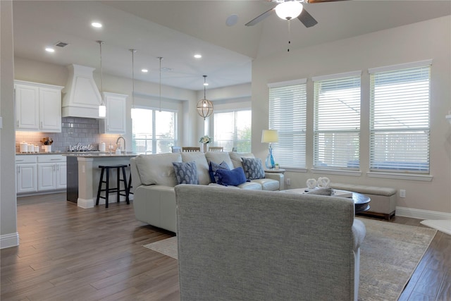 living room with ceiling fan, recessed lighting, baseboards, visible vents, and dark wood-style floors