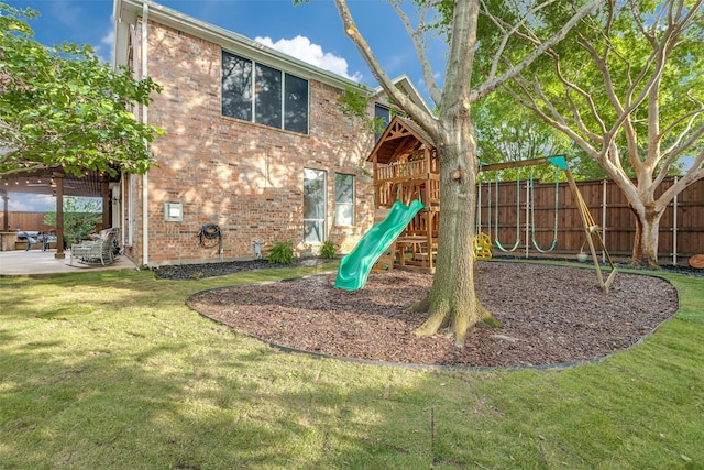 view of playground with a yard and fence