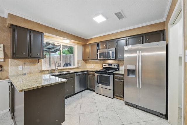 kitchen with light stone countertops, appliances with stainless steel finishes, a sink, a peninsula, and visible vents