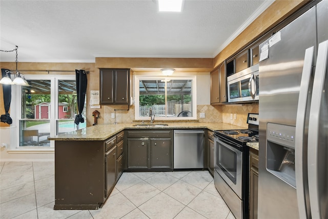kitchen with backsplash, appliances with stainless steel finishes, a sink, a peninsula, and ornamental molding