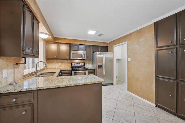 kitchen with backsplash, visible vents, appliances with stainless steel finishes, a sink, and baseboards
