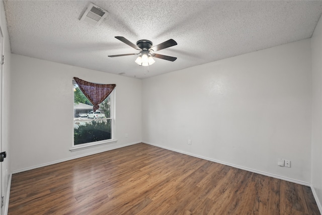 unfurnished room featuring ceiling fan, a textured ceiling, baseboards, wood finished floors, and visible vents