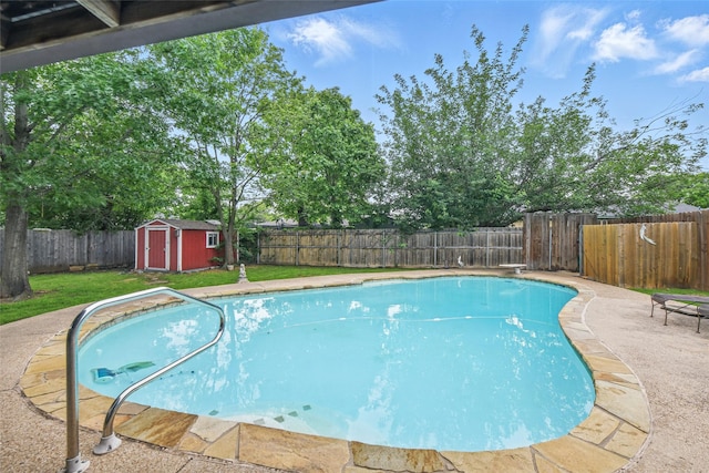 view of pool featuring a storage shed, a lawn, and a fenced backyard