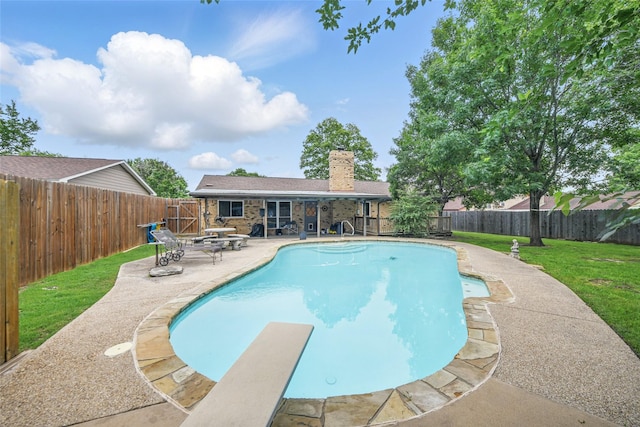 view of swimming pool with a diving board, a fenced backyard, a fenced in pool, a patio area, and a lawn