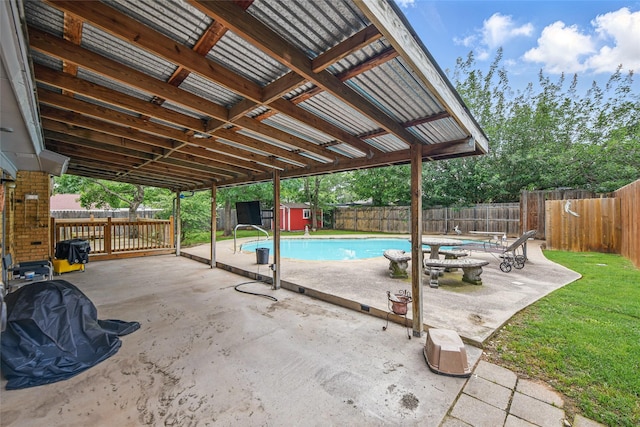 view of swimming pool featuring an outbuilding, a fenced in pool, a shed, a fenced backyard, and a patio
