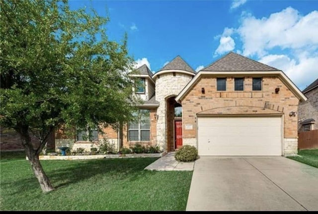 french country style house with driveway, a front yard, brick siding, an attached garage, and stone siding