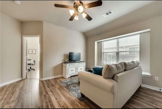 living room featuring a ceiling fan, baseboards, visible vents, and wood finished floors