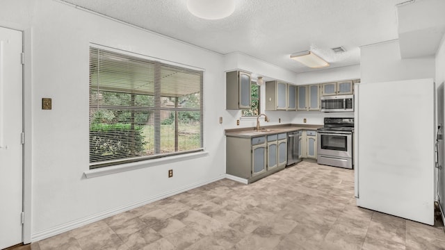 kitchen featuring visible vents, a textured ceiling, a sink, gray cabinetry, and stainless steel appliances