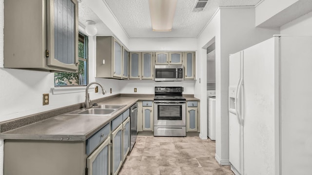 kitchen featuring dark countertops, appliances with stainless steel finishes, a sink, a textured ceiling, and visible vents