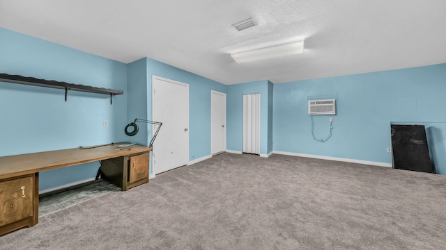 unfurnished office featuring baseboards, carpet flooring, a wall mounted air conditioner, and visible vents
