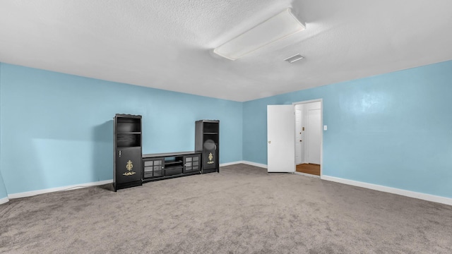 unfurnished living room featuring baseboards, carpet, and a textured ceiling