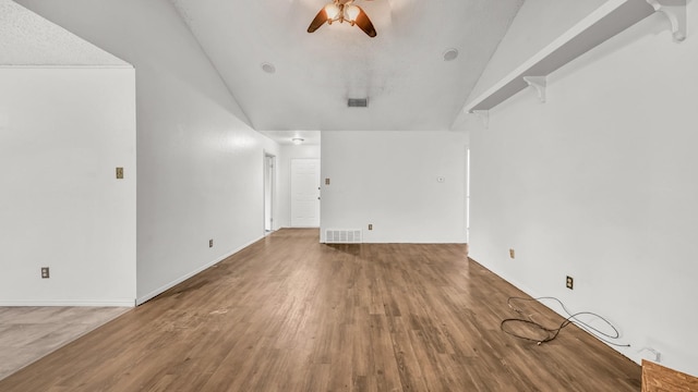 unfurnished living room with vaulted ceiling, a ceiling fan, wood finished floors, and visible vents