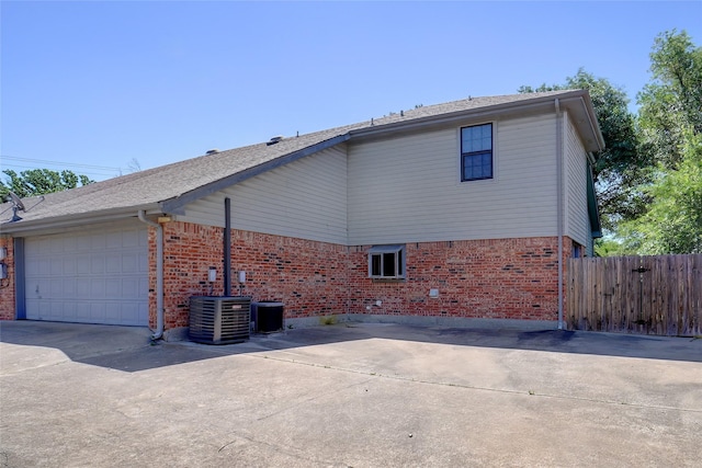 5834 Westhaven Dr Unit B, Fort Worth, TX 76132 - view of side of property with driveway, brick siding, fence, an attached garage, and central AC