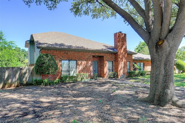 5834 Westhaven Dr Unit B, Fort Worth, TX 76132 - view of front of property with a chimney, brick siding, a shingled roof, and fence