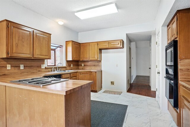 5834 Westhaven Dr Unit B, Fort Worth, TX 76132 - kitchen with a textured ceiling, stainless steel electric cooktop, marble finish floor, a sink, and a peninsula