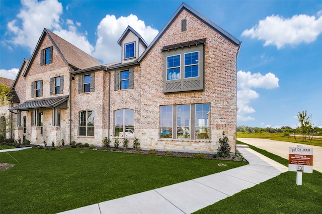 view of front facade featuring brick siding and a front yard