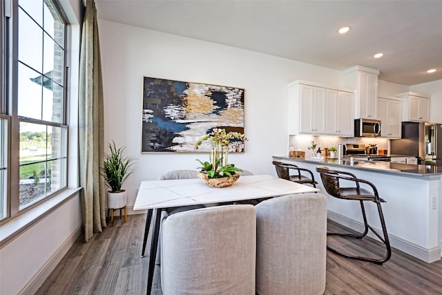 dining area featuring recessed lighting, baseboards, and wood finished floors