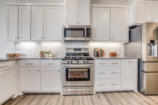 kitchen featuring light wood-style floors, decorative backsplash, white cabinetry, and stainless steel appliances