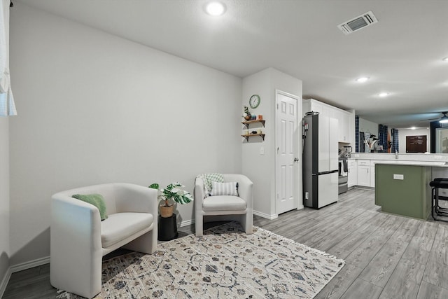 living area featuring recessed lighting, baseboards, light wood finished floors, and visible vents