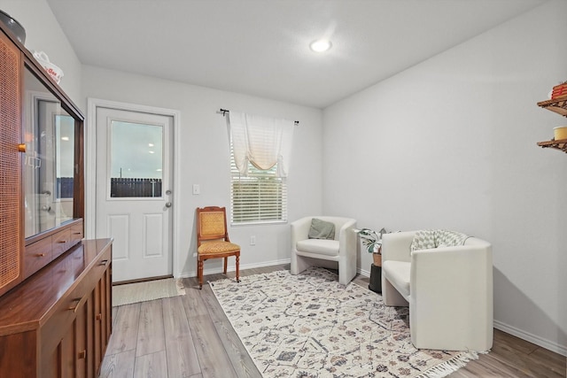living area with recessed lighting, baseboards, and light wood finished floors