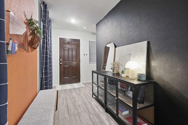 foyer entrance with a textured wall and wood finished floors