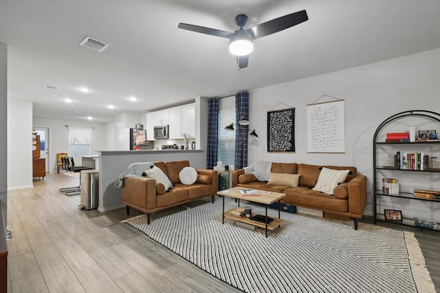 living area with a ceiling fan, visible vents, baseboards, light wood-style floors, and recessed lighting