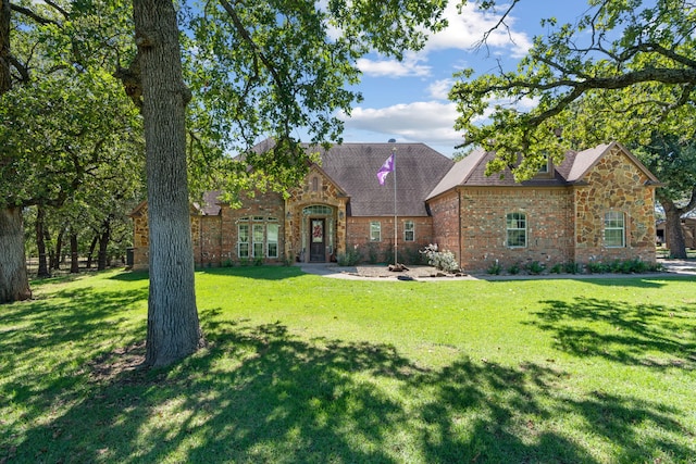 view of front facade featuring brick siding and a front yard