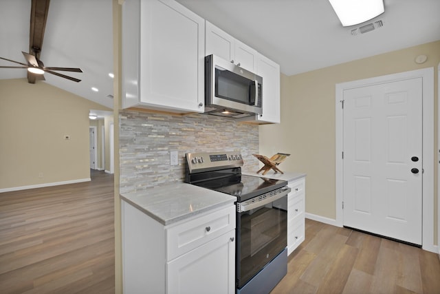 kitchen featuring visible vents, baseboards, light wood finished floors, appliances with stainless steel finishes, and backsplash