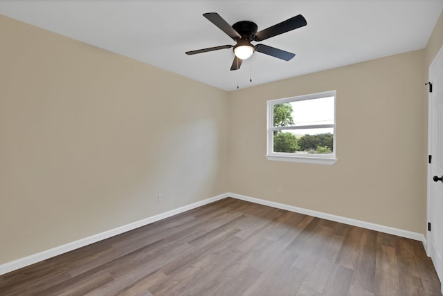 spare room featuring baseboards, a ceiling fan, and wood finished floors