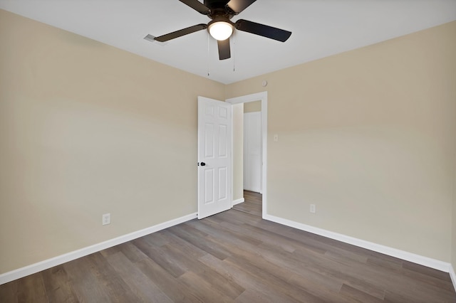 spare room featuring baseboards, a ceiling fan, and wood finished floors