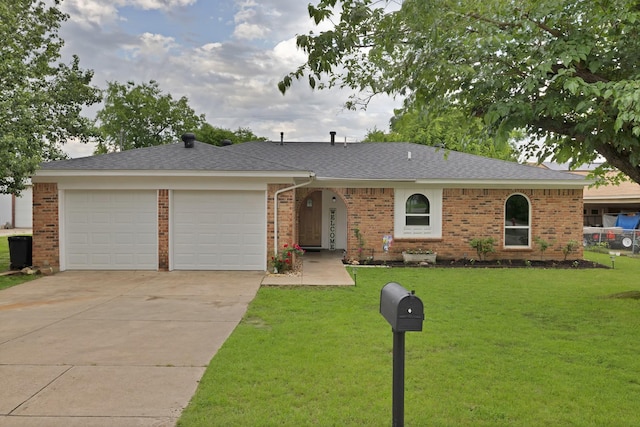 single story home featuring brick siding, a garage, a front lawn, and concrete driveway