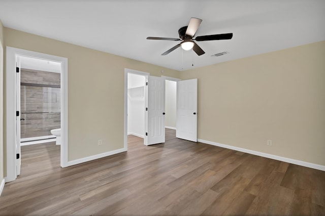 unfurnished bedroom featuring baseboards, wood finished floors, and visible vents