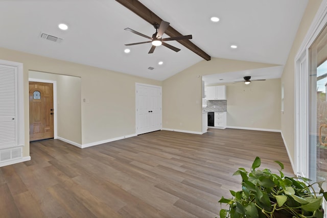 unfurnished living room with visible vents, a ceiling fan, and wood finished floors