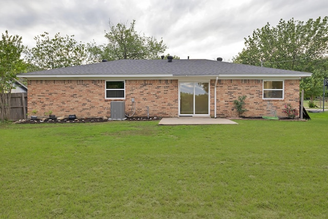 back of house featuring fence, central AC, brick siding, a patio area, and a lawn