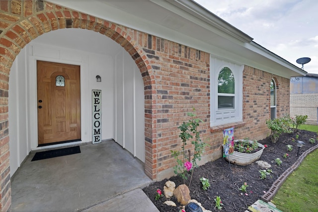 doorway to property featuring brick siding