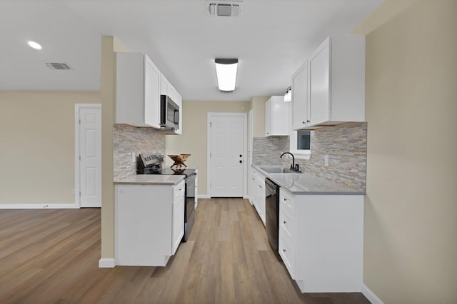 kitchen with light countertops, stainless steel appliances, visible vents, and a sink