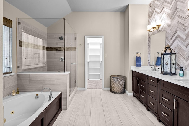 bathroom with a sink, a tub with jets, a shower stall, double vanity, and baseboards