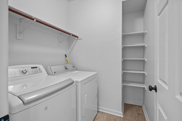 laundry room with laundry area, baseboards, and washing machine and clothes dryer