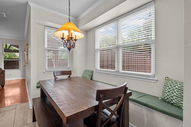 dining space featuring baseboards, a notable chandelier, ornamental molding, and light tile patterned floors