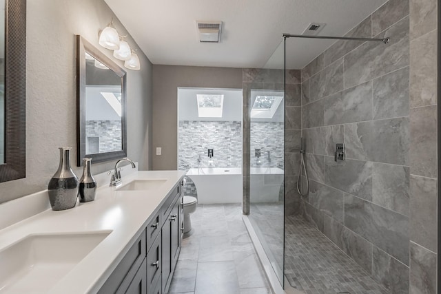 bathroom with a sink, walk in shower, a freestanding bath, and a skylight