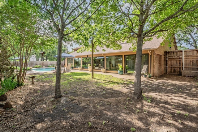 view of yard featuring a fenced in pool, a fenced backyard, and a patio