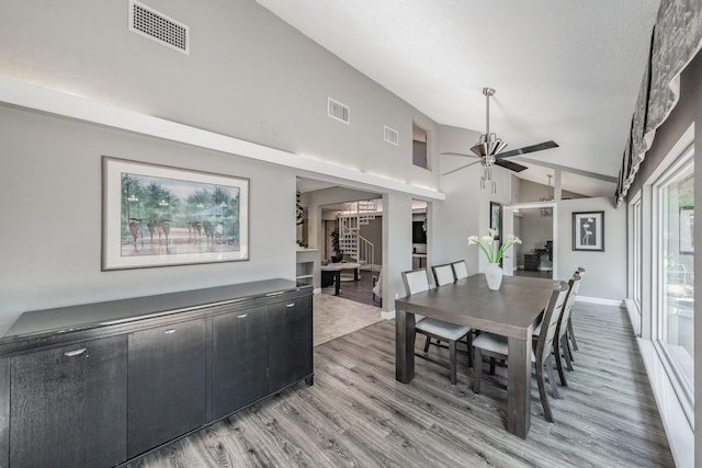 dining space featuring ceiling fan, visible vents, light wood-style flooring, and lofted ceiling