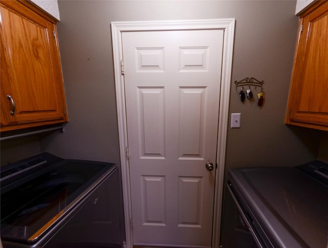 laundry area with separate washer and dryer and cabinet space